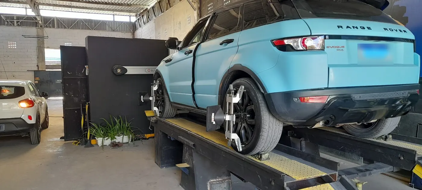 Range Rover azul-claro na bancada de alinhamento da oficina
